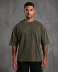 Man wearing a green t-shirt with text on a gray background