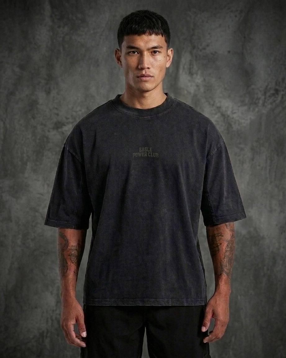 Person wearing a black t-shirt with text on a gray background