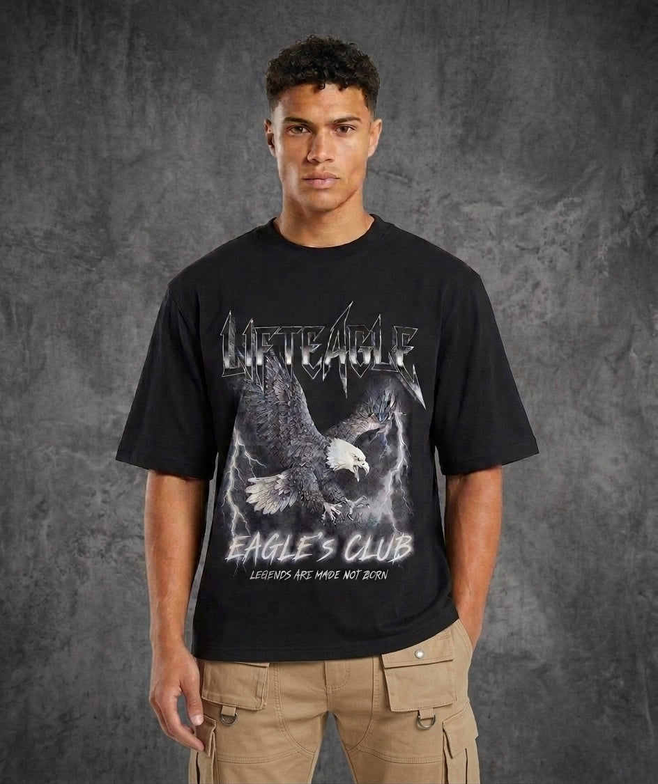 Person wearing a black t-shirt with an eagle design and text on a gray background